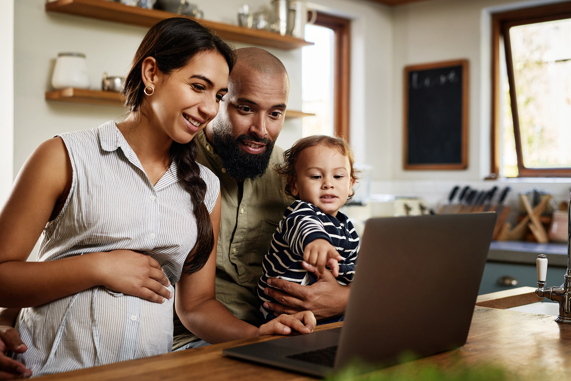 Shot of a happy young family using a laptop together at home
