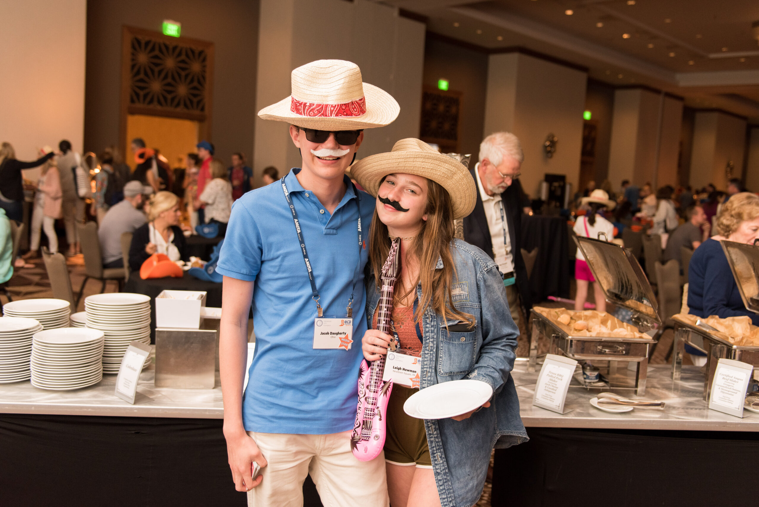 A boy and girl stand in front of buffet with costumes on. 