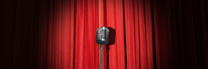A red curtain with a microphone in the spotlight.