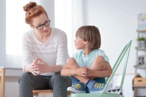 Woman conducting therapy with a young boy who has Autism and OCD from the research that she has