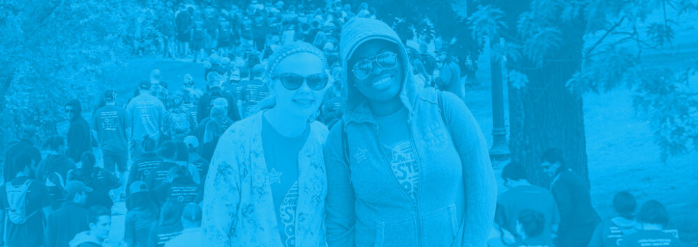 Image of a black woman and a white woman smiling, wearing and IOCDF OCD Walk shirt.