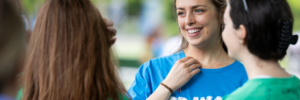 Woman in a blue OCD Walk T-shirt smiling in a group of people