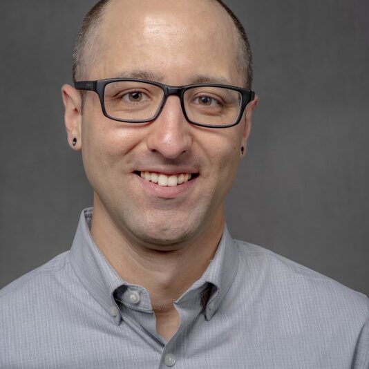 Jonathan Clark 6.10.25 White man with glasses and black earrings.