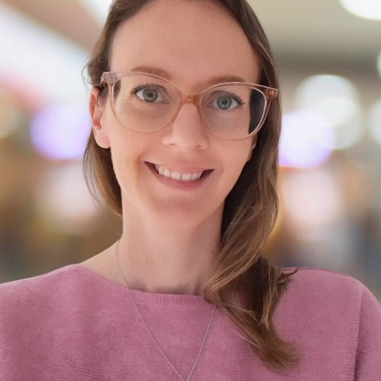 Leigh Sheppard 6.10.25 White woman with blond hair, glasses and a pink top.