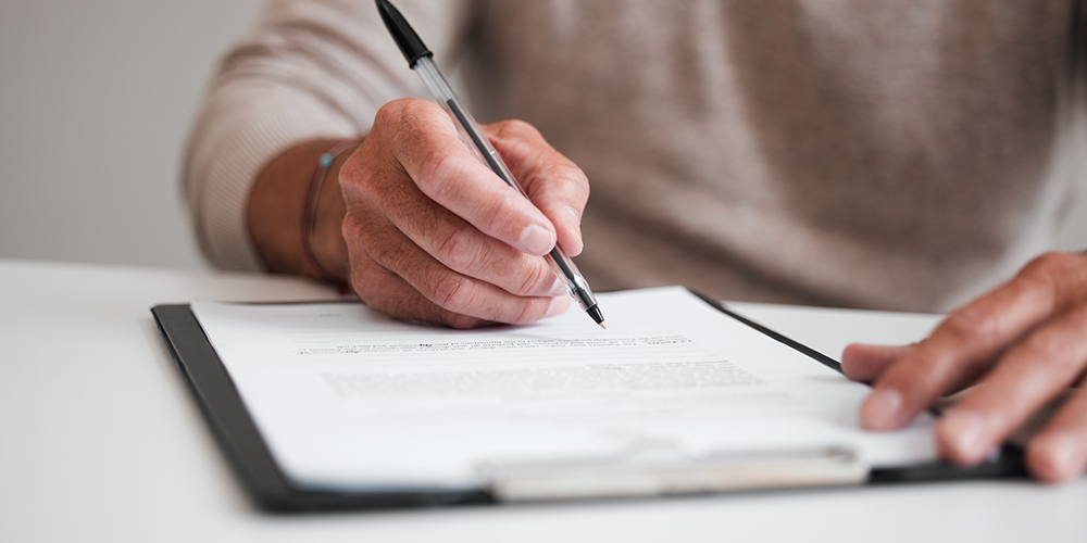 On the dotted line filling out a form on a clipboard