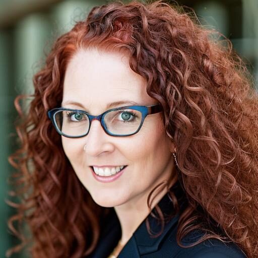 Stacey Black 6.10.25 White woman with red curly hair and glasses.